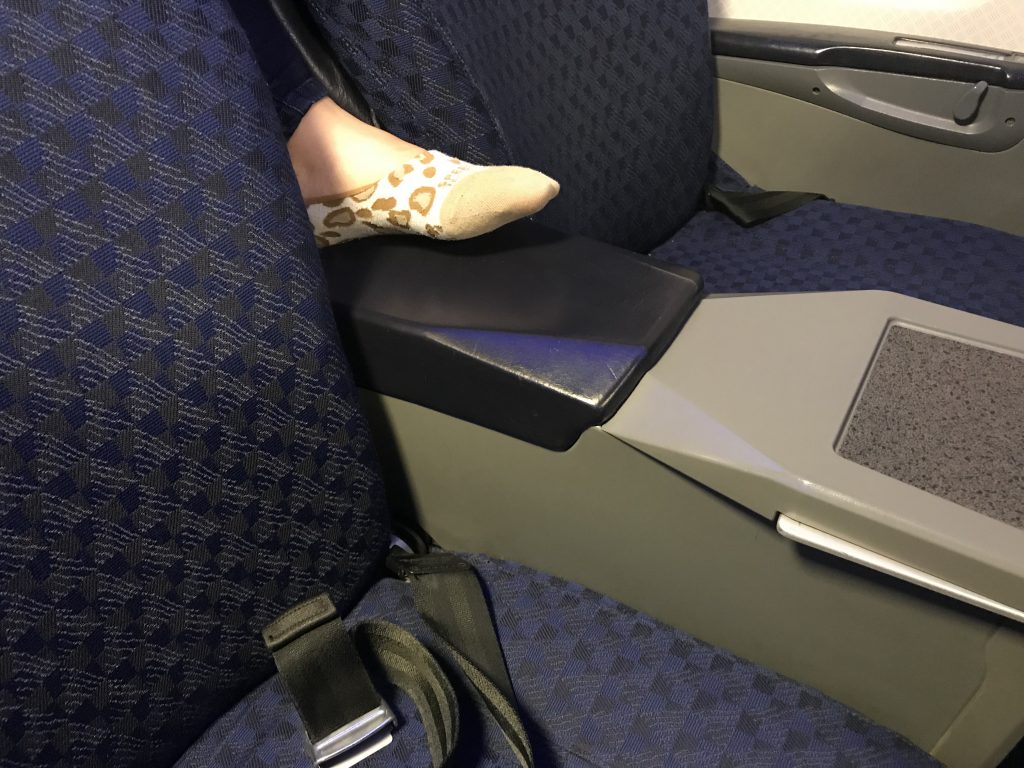 Foot between seats in first class.