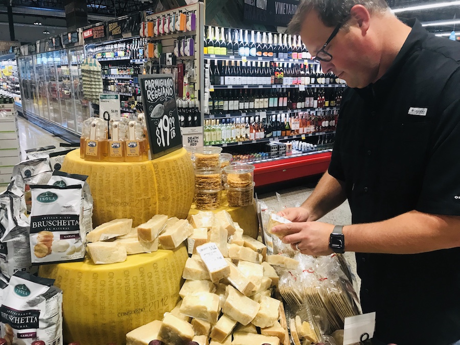 Steve selects a piece of Parmigiano Reggiano cheese at Whole Foods. 